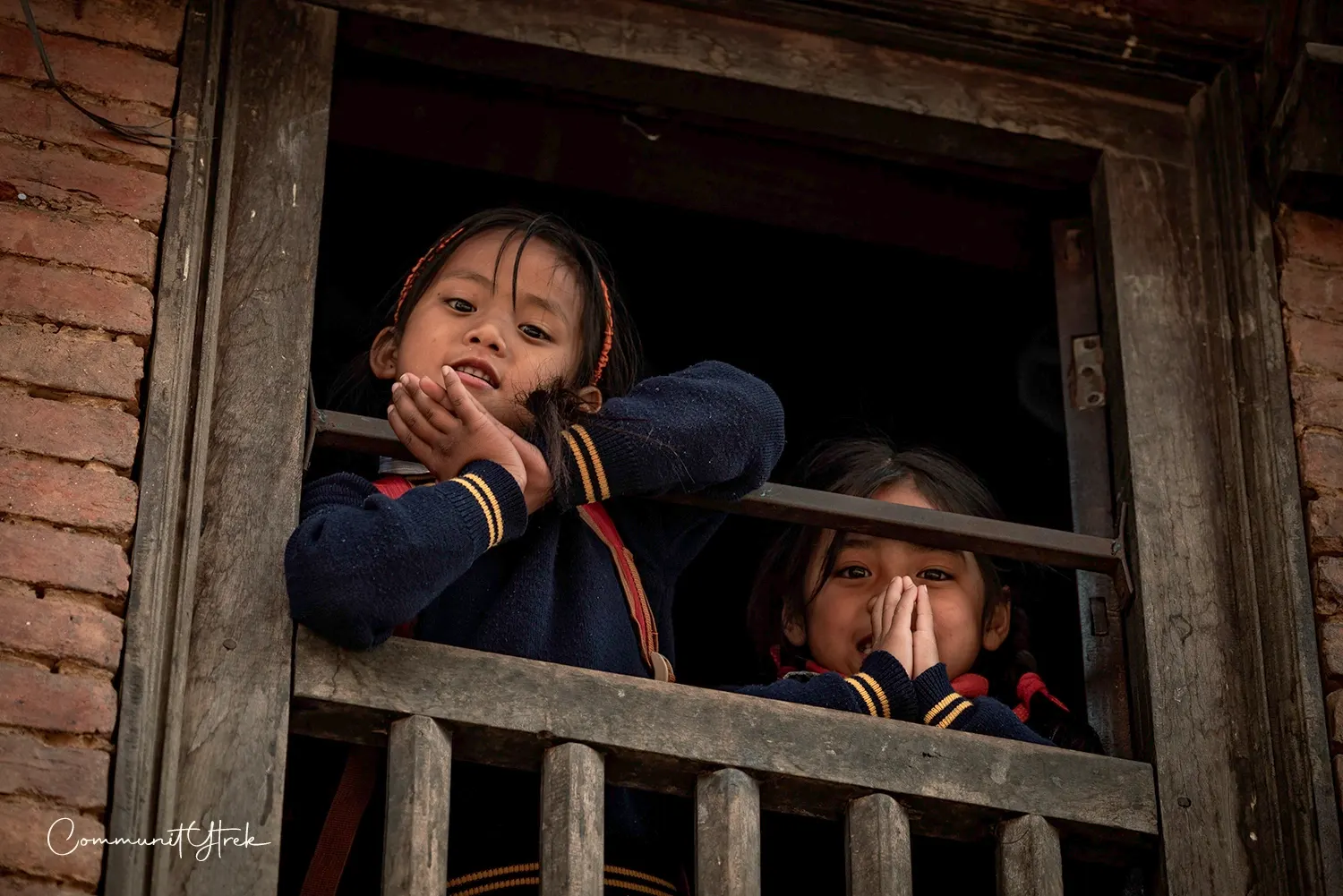 Little girls greeting from a traditional home window in Panauti, Kavre, Nepal