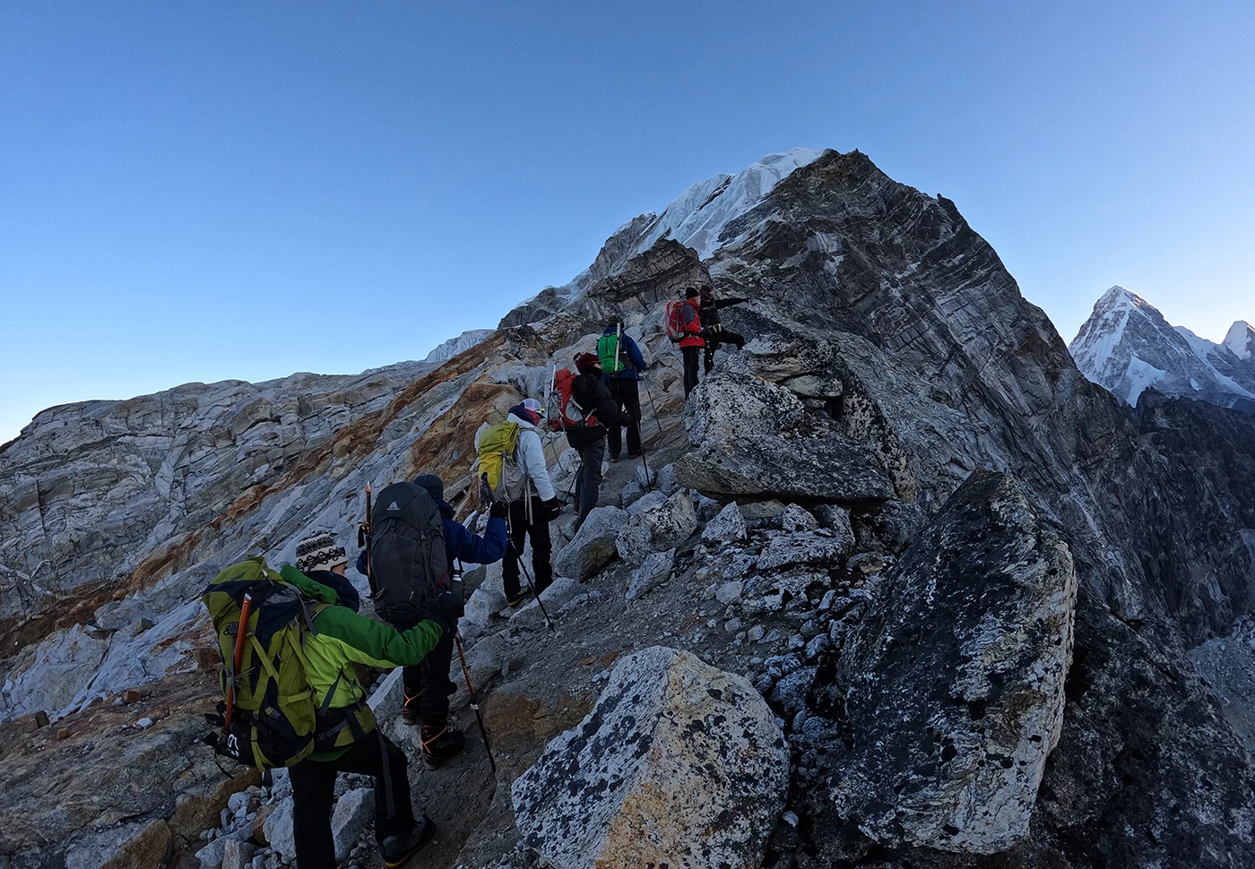 Trekker walking along a rocky trail below Lobuche Peak in Nepal